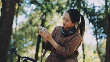 bicicleta, mujer y teléfono en ciudad sensación emocionado y contento acerca de mensaje mientras al aire libre en verano con de moda mirar. eco simpático transporte para carbón huella hembra en un bicicleta utilizando 5g red video