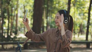 fiets, vrouw en telefoon in stad gevoel opgewonden en gelukkig over bericht terwijl buitenshuis in zomer met modieus Look. eco vriendelijk vervoer voor koolstof voetafdruk vrouw Aan een fiets gebruik makend van 5g netwerk video