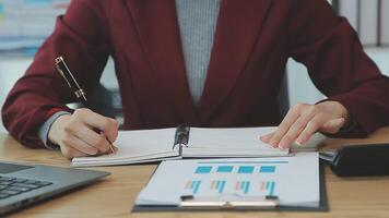 Asian Businesswoman Using laptop computer and working at office with calculator document on desk, doing planning analyzing the financial report, business plan investment, finance analysis concept. video