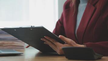 Asian Businesswoman Using laptop computer and working at office with calculator document on desk, doing planning analyzing the financial report, business plan investment, finance analysis concept. video