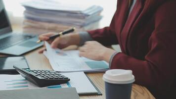 Asian Businesswoman Using laptop computer and working at office with calculator document on desk, doing planning analyzing the financial report, business plan investment, finance analysis concept. video