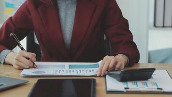 Asian Businesswoman Using laptop computer and working at office with calculator document on desk, doing planning analyzing the financial report, business plan investment, finance analysis concept. video