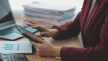 Asian Businesswoman Using laptop computer and working at office with calculator document on desk, doing planning analyzing the financial report, business plan investment, finance analysis concept. video