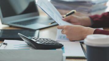 Asian Businesswoman Using laptop computer and working at office with calculator document on desk, doing planning analyzing the financial report, business plan investment, finance analysis concept. video