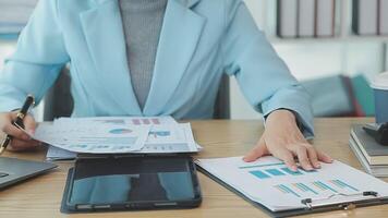 Asian Businesswoman Using laptop computer and working at office with calculator document on desk, doing planning analyzing the financial report, business plan investment, finance analysis concept. video