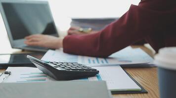 Asian Businesswoman Using laptop computer and working at office with calculator document on desk, doing planning analyzing the financial report, business plan investment, finance analysis concept. video