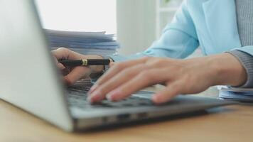 Asian Businesswoman Using laptop computer and working at office with calculator document on desk, doing planning analyzing the financial report, business plan investment, finance analysis concept. video