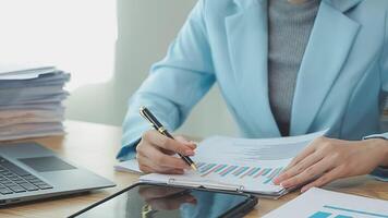 Asian Businesswoman Using laptop computer and working at office with calculator document on desk, doing planning analyzing the financial report, business plan investment, finance analysis concept. video