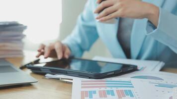 Asian Businesswoman Using laptop computer and working at office with calculator document on desk, doing planning analyzing the financial report, business plan investment, finance analysis concept. video