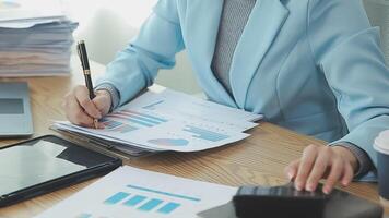 Asian Businesswoman Using laptop computer and working at office with calculator document on desk, doing planning analyzing the financial report, business plan investment, finance analysis concept. video