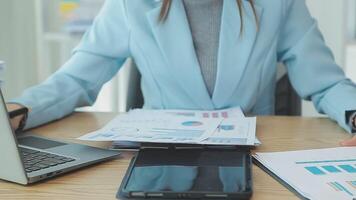 Asian Businesswoman Using laptop computer and working at office with calculator document on desk, doing planning analyzing the financial report, business plan investment, finance analysis concept. video