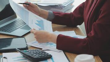 Asian Businesswoman Using laptop computer and working at office with calculator document on desk, doing planning analyzing the financial report, business plan investment, finance analysis concept. video