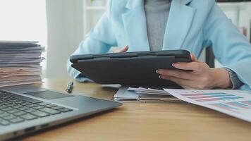 Asian Businesswoman Using laptop computer and working at office with calculator document on desk, doing planning analyzing the financial report, business plan investment, finance analysis concept. video