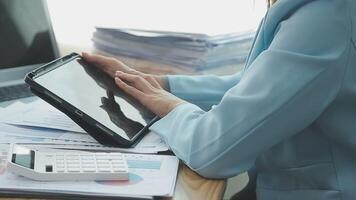 Asian Businesswoman Using laptop computer and working at office with calculator document on desk, doing planning analyzing the financial report, business plan investment, finance analysis concept. video