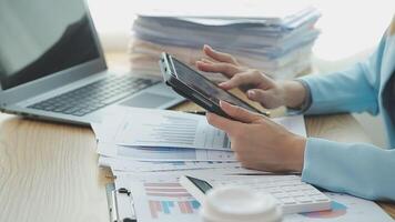 Asian Businesswoman Using laptop computer and working at office with calculator document on desk, doing planning analyzing the financial report, business plan investment, finance analysis concept. video