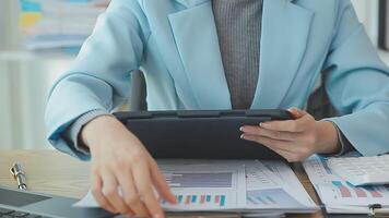 Asian Businesswoman Using laptop computer and working at office with calculator document on desk, doing planning analyzing the financial report, business plan investment, finance analysis concept. video