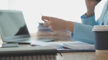 Asian Businesswoman Using laptop computer and working at office with calculator document on desk, doing planning analyzing the financial report, business plan investment, finance analysis concept. video
