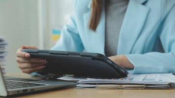 Asian Businesswoman Using laptop computer and working at office with calculator document on desk, doing planning analyzing the financial report, business plan investment, finance analysis concept. video