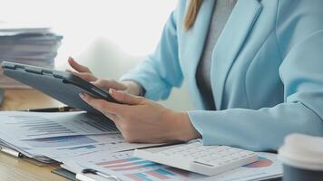 Asian Businesswoman Using laptop computer and working at office with calculator document on desk, doing planning analyzing the financial report, business plan investment, finance analysis concept. video