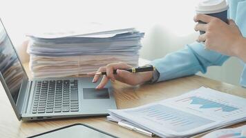 Asian Businesswoman Using laptop computer and working at office with calculator document on desk, doing planning analyzing the financial report, business plan investment, finance analysis concept. video