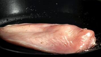 kip filet valt in een frituren pan. gefilmd Aan een hoge snelheid camera Bij 1000 fps. hoog kwaliteit full HD beeldmateriaal video