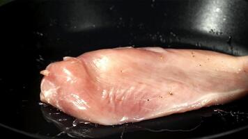 Hähnchen Filet Stürze in ein braten Pfanne. gefilmt auf ein schnelle Geschwindigkeit Kamera beim 1000 fps. hoch Qualität fullhd Aufnahmen video