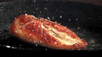zout druppels Aan gebakken kip vlees. gefilmd Aan een hoge snelheid camera Bij 1000 fps. hoog kwaliteit full HD beeldmateriaal video