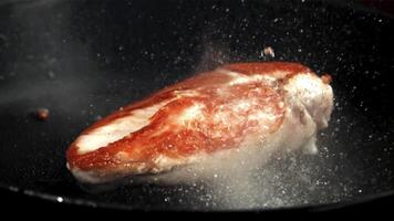 ein Stück von Hähnchen Fleisch ist gebraten im ein braten Pfanne. gefilmt auf ein schnelle Geschwindigkeit Kamera beim 1000 fps. hoch Qualität fullhd Aufnahmen video