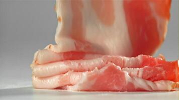Bacon falling on white background. Filmed on a high-speed camera at 1000 fps. High quality FullHD footage video