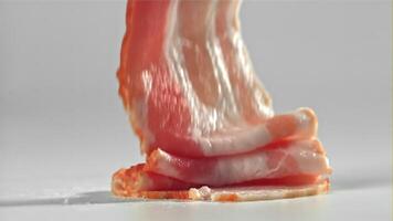 Bacon falling on white background. Filmed on a high-speed camera at 1000 fps. High quality FullHD footage video