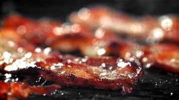 The bacon is fried in a pan with a splash of oil. Filmed on a high-speed camera at 1000 fps. High quality FullHD footage video