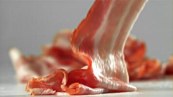 Bacon falling on white background. Filmed on a high-speed camera at 1000 fps. High quality FullHD footage video