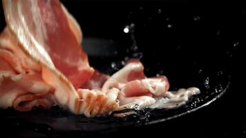 crudo Bacon cascate in il piatto. girato su un' alta velocità telecamera a 1000 fps. alto qualità FullHD metraggio video