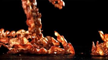 Bacon falling on a black background. Filmed on a high-speed camera at 1000 fps. High quality FullHD footage video