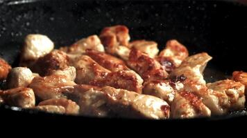 Frying chicken pieces in a frying pan. Filmed on a high-speed camera at 1000 fps. High quality FullHD footage video