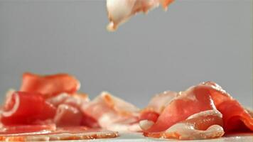 Bacon falling on white background. Filmed on a high-speed camera at 1000 fps. High quality FullHD footage video