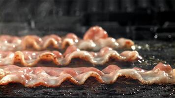 bacon é frito dentro uma frigideira. filmado em uma alta velocidade Câmera às 1000 fps. Alto qualidade fullhd cenas video