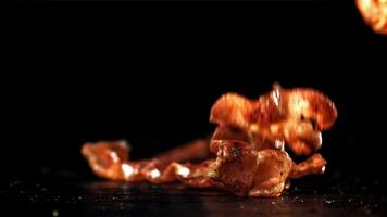 Bacon falling on a black background. Filmed on a high-speed camera at 1000 fps. High quality FullHD footage video