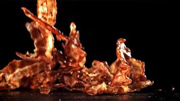 Bacon falling on a black background. Filmed on a high-speed camera at 1000 fps. High quality FullHD footage video