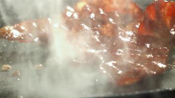 The bacon is fried in a pan with a splash of oil. Filmed on a high-speed camera at 1000 fps. High quality FullHD footage video