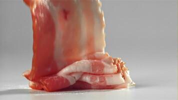 Bacon falling on white background. Filmed on a high-speed camera at 1000 fps. High quality FullHD footage video