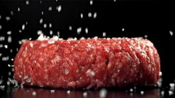 The cook sprinkles salt on the meat burger. Filmed on a high-speed camera at 1000 fps. High quality FullHD footage video