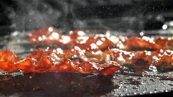 bacon é frito dentro uma frigideira. filmado em uma alta velocidade Câmera às 1000 fps. Alto qualidade fullhd cenas video