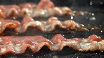 Bacon is fried in a pan. Filmed on a high-speed camera at 1000 fps. High quality FullHD footage video