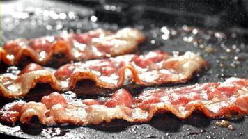 Bacon è fritte nel un' padella. girato su un' alta velocità telecamera a 1000 fps. alto qualità FullHD metraggio video