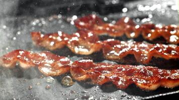 bacon é frito dentro uma frigideira. filmado em uma alta velocidade Câmera às 1000 fps. Alto qualidade fullhd cenas video