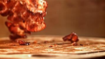 Roasted slices of bacon fall on a wooden table. Filmed on a high-speed camera at 1000 fps. High quality FullHD footage video