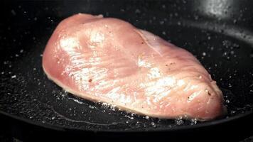 Chicken fillet is fried in a frying pan. Filmed on a high-speed camera at 1000 fps. High quality FullHD footage video