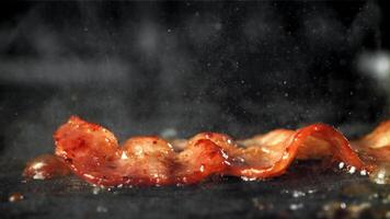 bacon é frito dentro uma frigideira. filmado em uma alta velocidade Câmera às 1000 fps. Alto qualidade fullhd cenas video