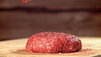 un Fresco carne de vaca hamburguesa caídas sobre un corte tablero. filmado en un alta velocidad cámara a 1000 fps. alto calidad full HD imágenes video